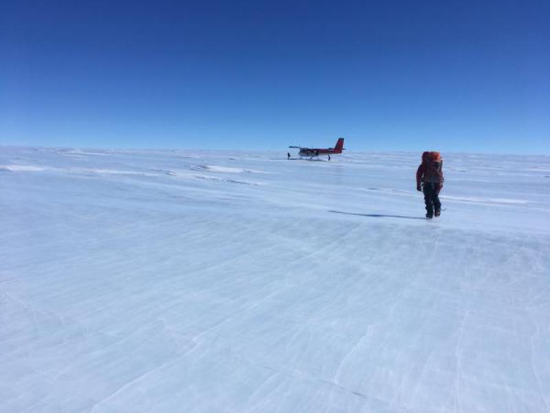  With a pack full of rocks, Mountaineer Scott Barry makes his way toward the Twin Otter aircraft for departure. East Antarctic Ice Sheet and Polar Plateau in the distance, with the nearest outcrop over 1,000 miles away along the Atlantic/Indian sector of Antarctica.