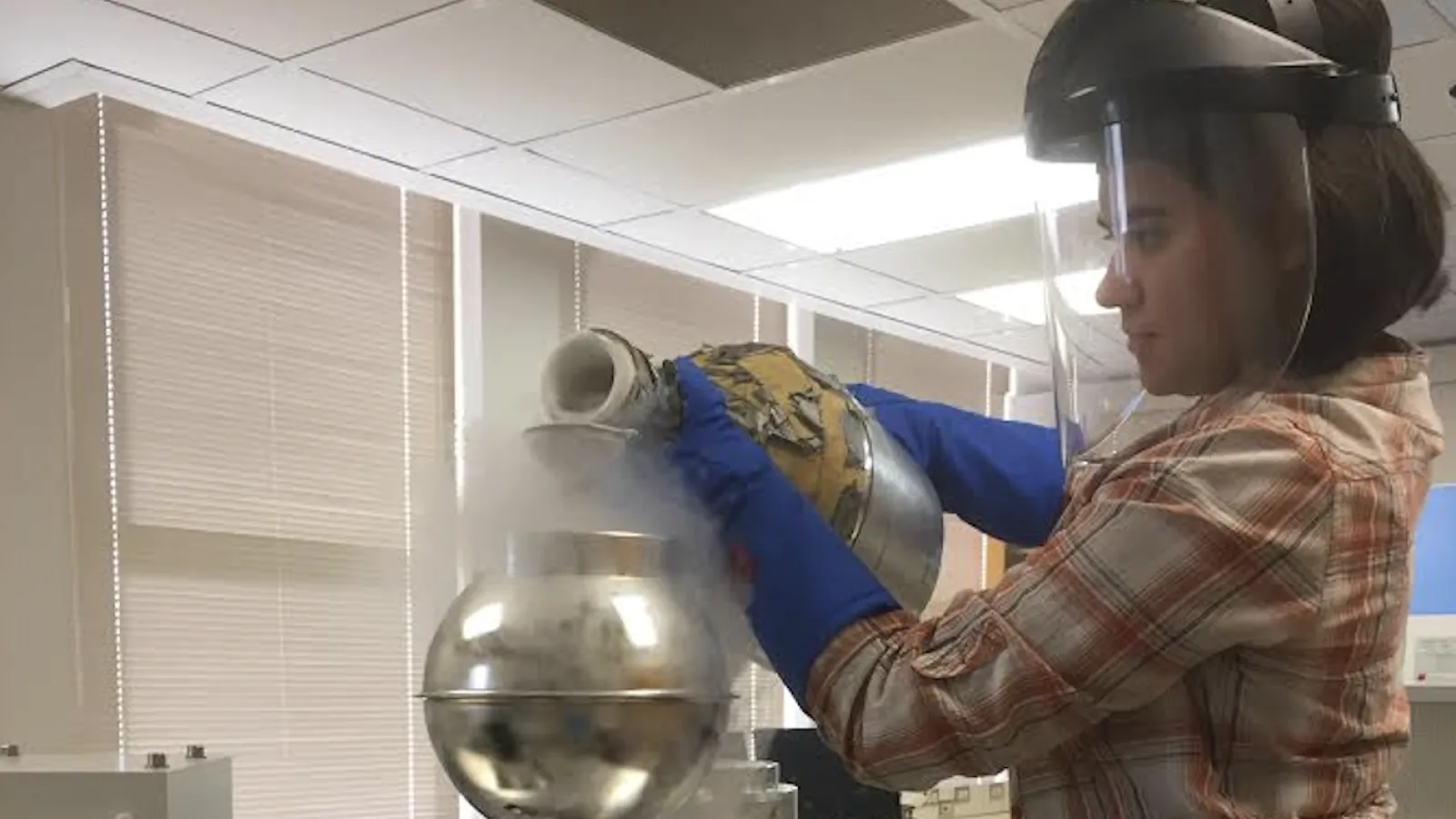 Graduate student Teresa Avila pours liquid nitrogen into an instrument