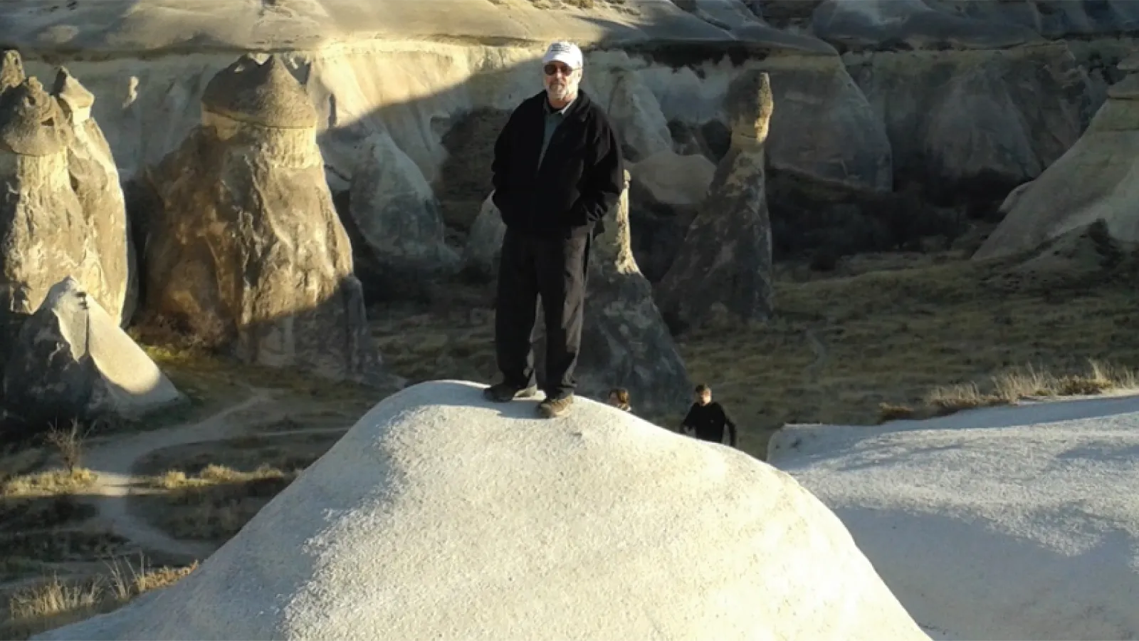 Michael Beathard stands atop a rock on a hike