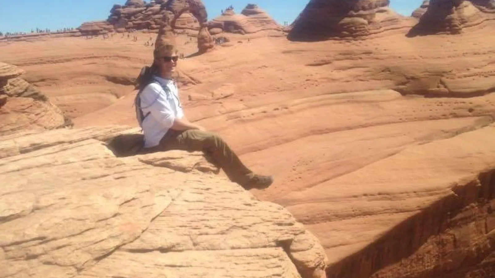 Brent Lary sitting on red sandstone at field camp