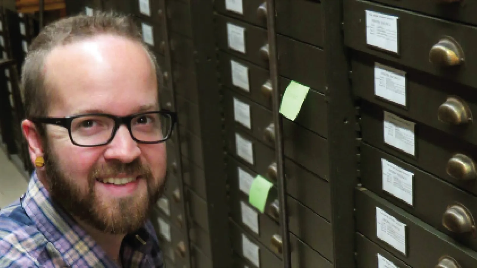 Davey Wright smiles while going through museum collections cabinets looking for fossils