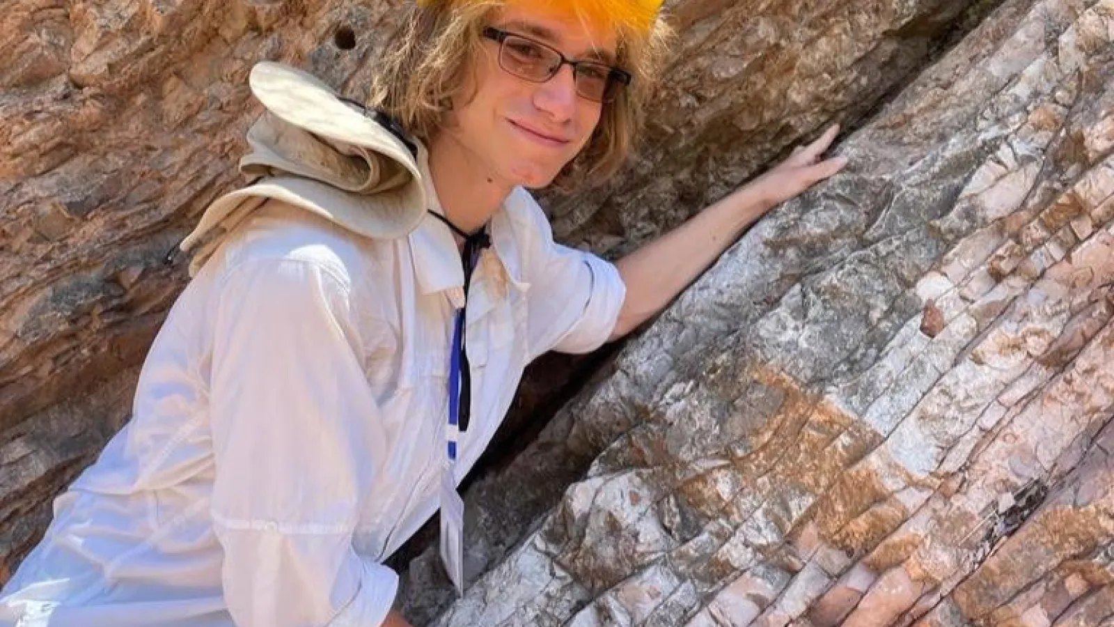 Brandon Bell in Italy leaning on an outcrop