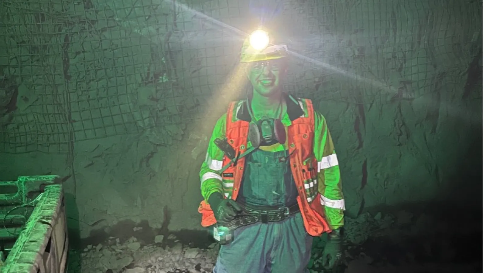 Ben Jones in reflective safety gear underground with headlamp light