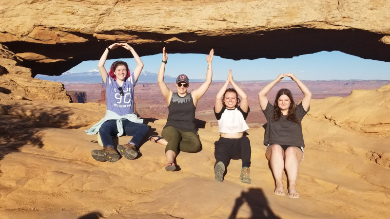Students and teaching assistants at Arches National Park during field camp make an O-H-I-O.