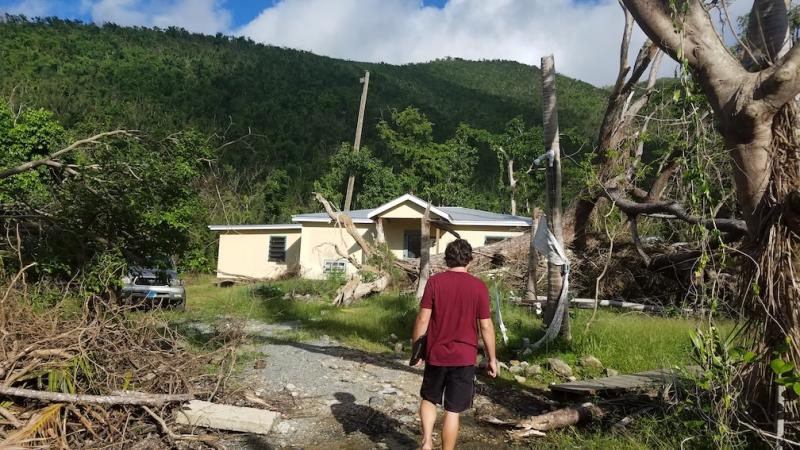 Student surveys house damaged by hurricane