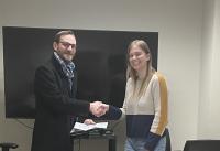 Photo of James M. Gentry (Director, Office of Postdoctoral Affairs) presenting the award to postdoc Dr. Ann Marie Hulver.