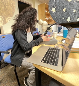 Graduate student Batoul Saad using a microscope.