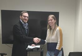 Photo of James M. Gentry (Director, Office of Postdoctoral Affairs) presenting the award to postdoc Dr. Ann Marie Hulver.