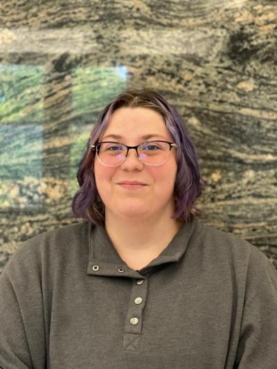 headshot of Megan O'Quin with rock sediment background