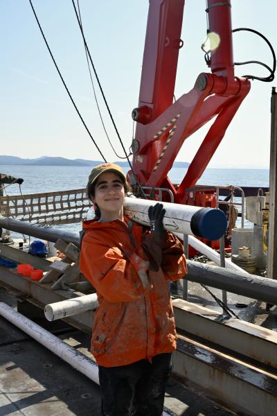 Batoul carrying a freshly recovered jumbo piston core section to the Multi Sensor Track (MST) van for physical property scanning at sea.