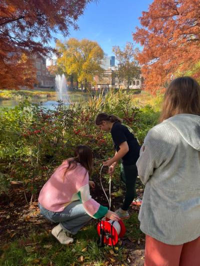 This image shows Madison Schaefer leading an activity abou contaminant transport in aquifers. See how a contaminant spreads between grains, pull contaminated water from a “well”, and filter it through activated carbon.
