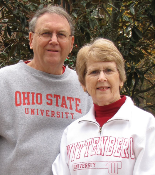 Mike and Cindy Morgan smiling at the camera. Mike is wearing an Ohio State sweatshirt and Cindy is wearing a Wittenburg sweatshirt.