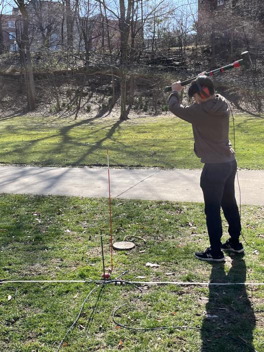 SES student Derrick Chen uses a sledgehammer to create the source for the survey.