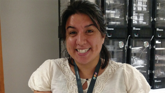 Kathy Ann Hollis smiling in front of collections in the Smithsonian