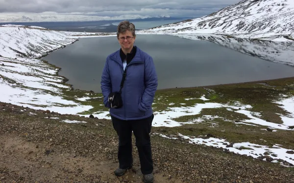 Alum Katie Lewandowski smiles in a snowy mountain terrain