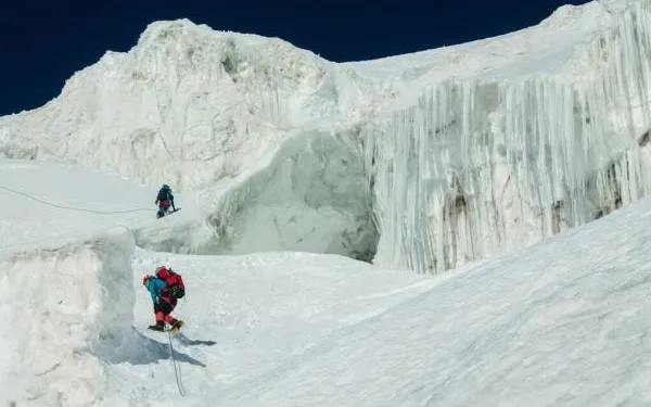 Two polar explorers climbing an icy landscape