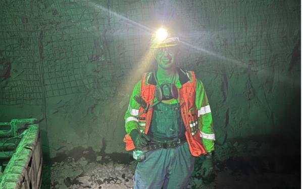 Ben Jones in reflective safety gear underground with headlamp light
