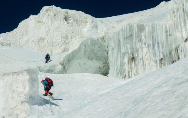 Two polar explorers climbing an icy landscape