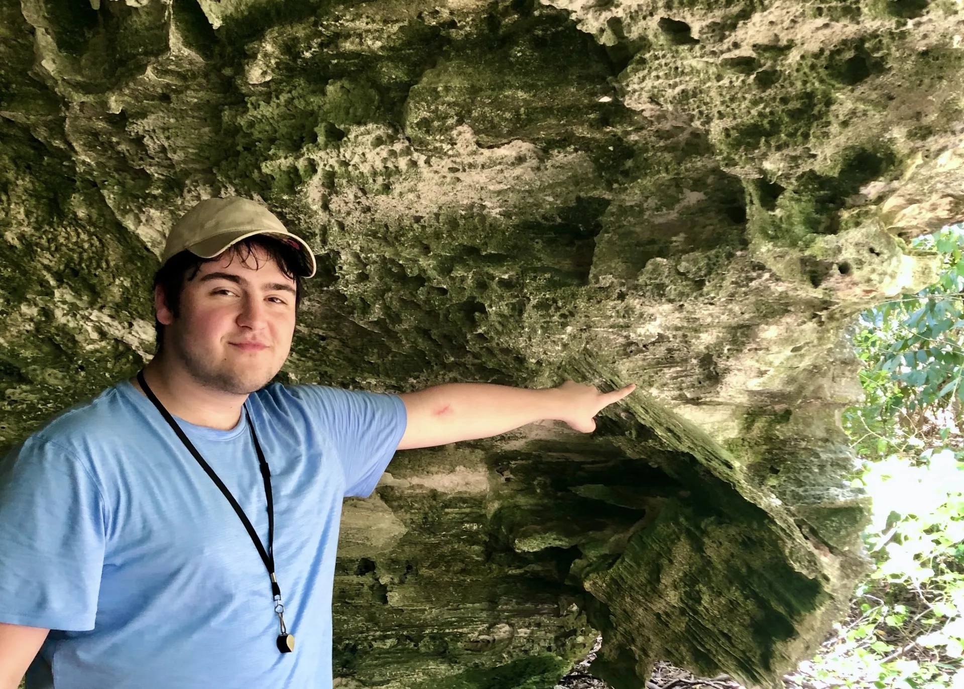 LJ smiling and pointing at a cave feature
