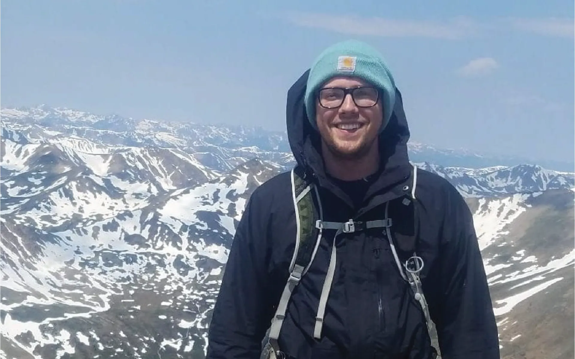 Graduate student Karl Wilhelmsen standing in front of mountains