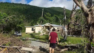Student surveys house damaged by hurricane