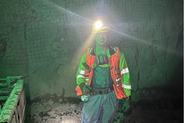 Ben Jones in reflective safety gear underground with headlamp light
