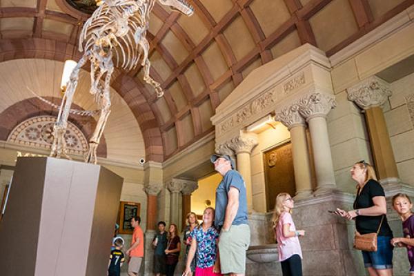 Visitors admire cryolophosaurus at open house. Photo Credit: Mark Schmitter