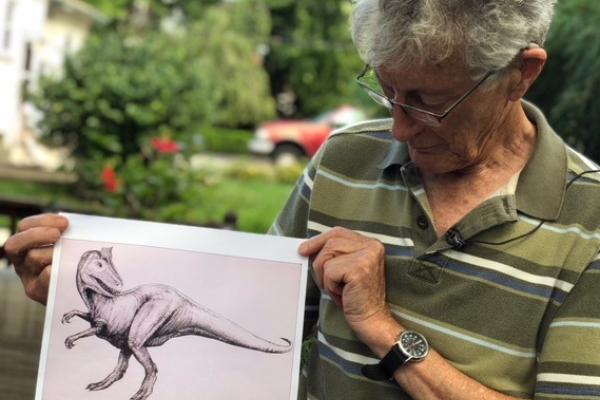 Professor Emeritus Elliot holds sketch of his dinosaur discovery for TV10.