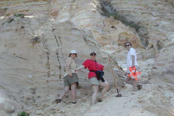 Hydrogeological field methods trip to Gulf Coastal Alabama. Three members of the Earth Sciences grad program pose for picture near rocky cliffside.