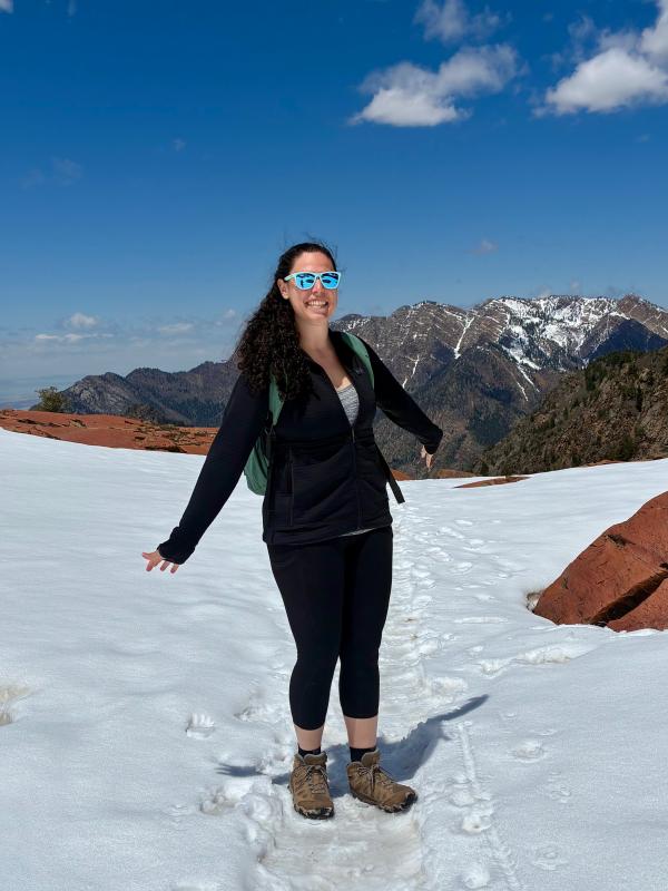 Girl on a mountain with a backpack and sunglasses