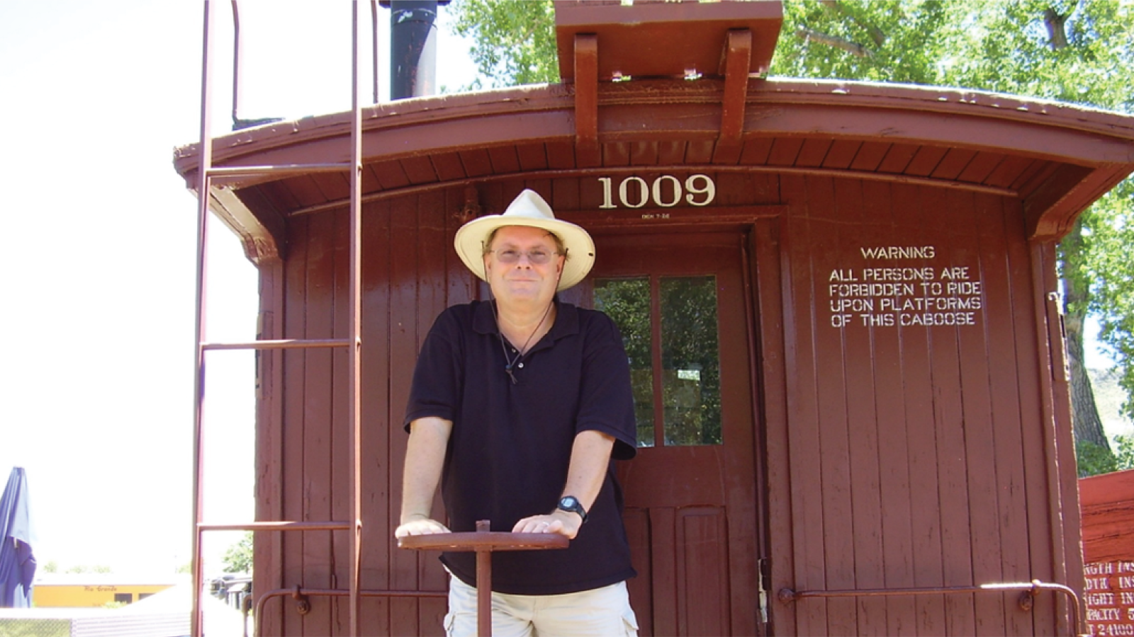 Mark Izold standing on a train car at the train museum in Golden, CO