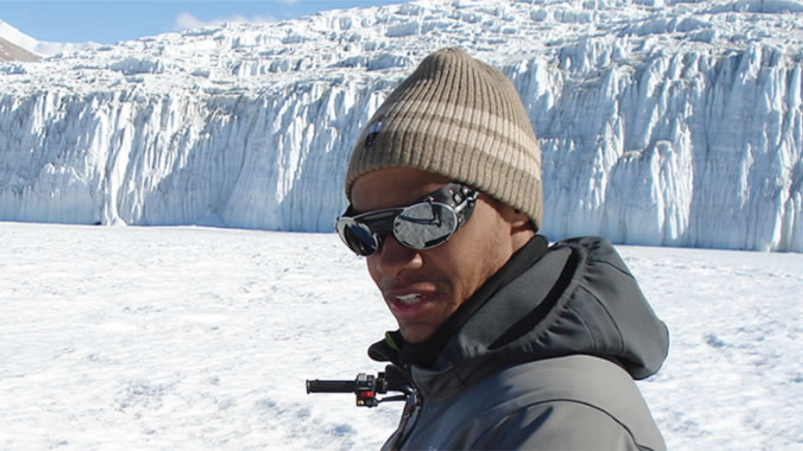 Derrick Lampkin doing field work in front of a glacial background