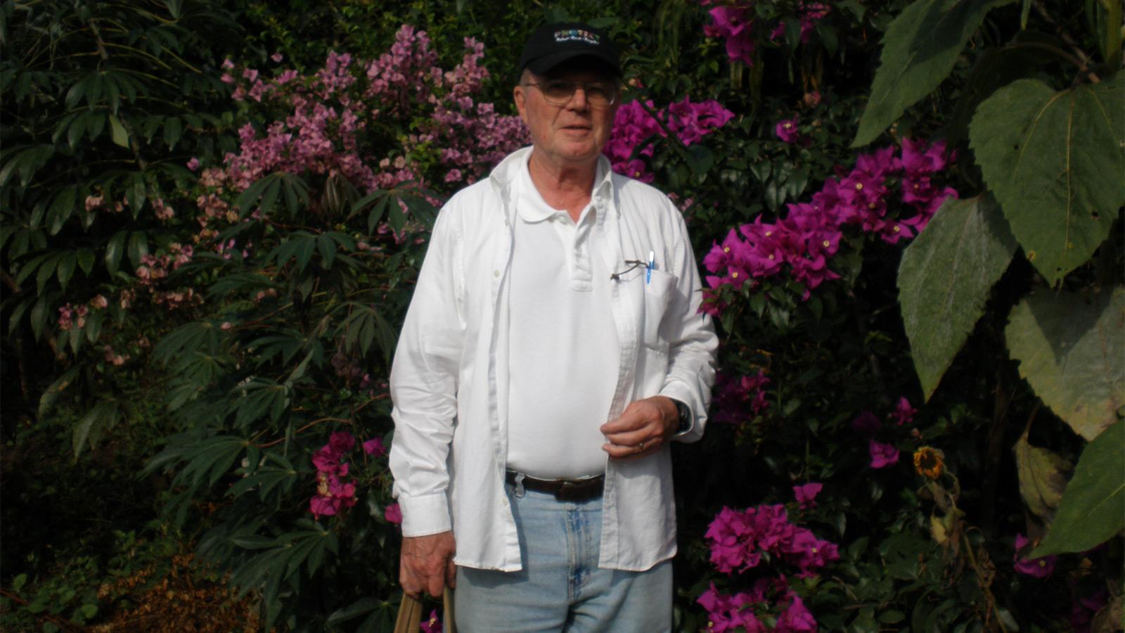 picture of Joe Wojcik standing in front of flowers