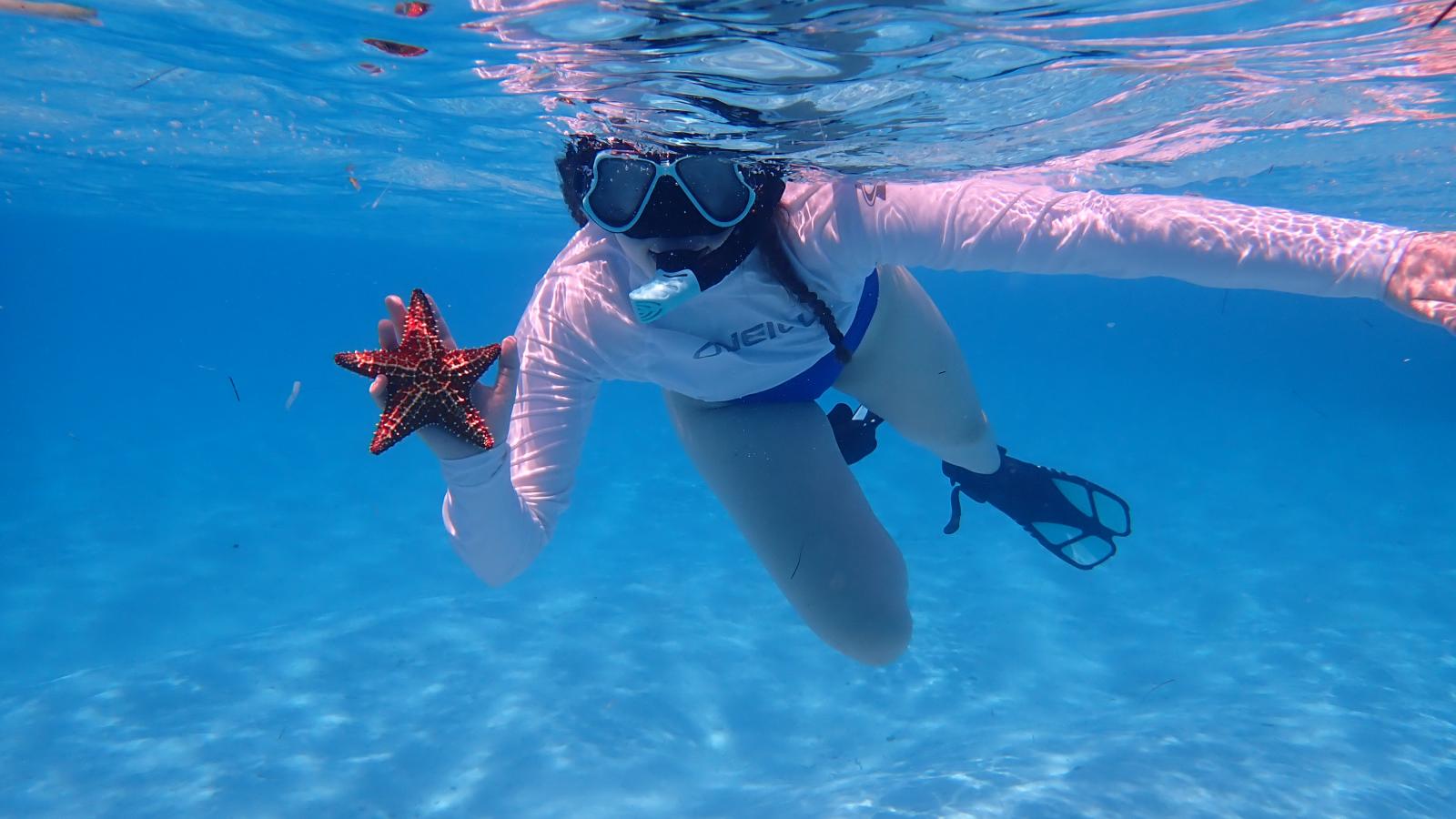 Aubree Steinmetz shows off a starfish while snorkeling.