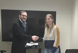 Photo of James M. Gentry (Director, Office of Postdoctoral Affairs) presenting the award to postdoc Dr. Ann Marie Hulver.
